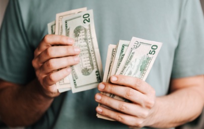 Crop man counting dollar banknotes