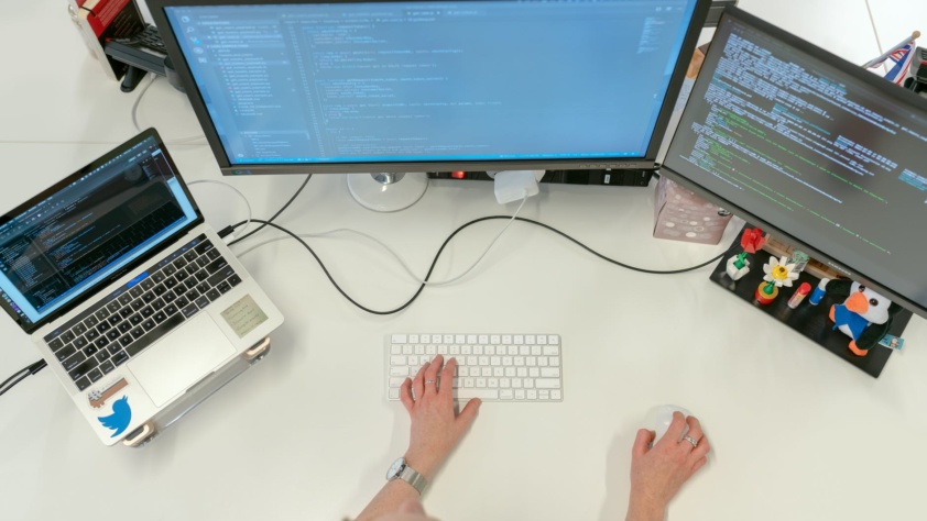 woman on desk in front of laptop, monitor, tab, side hustle
