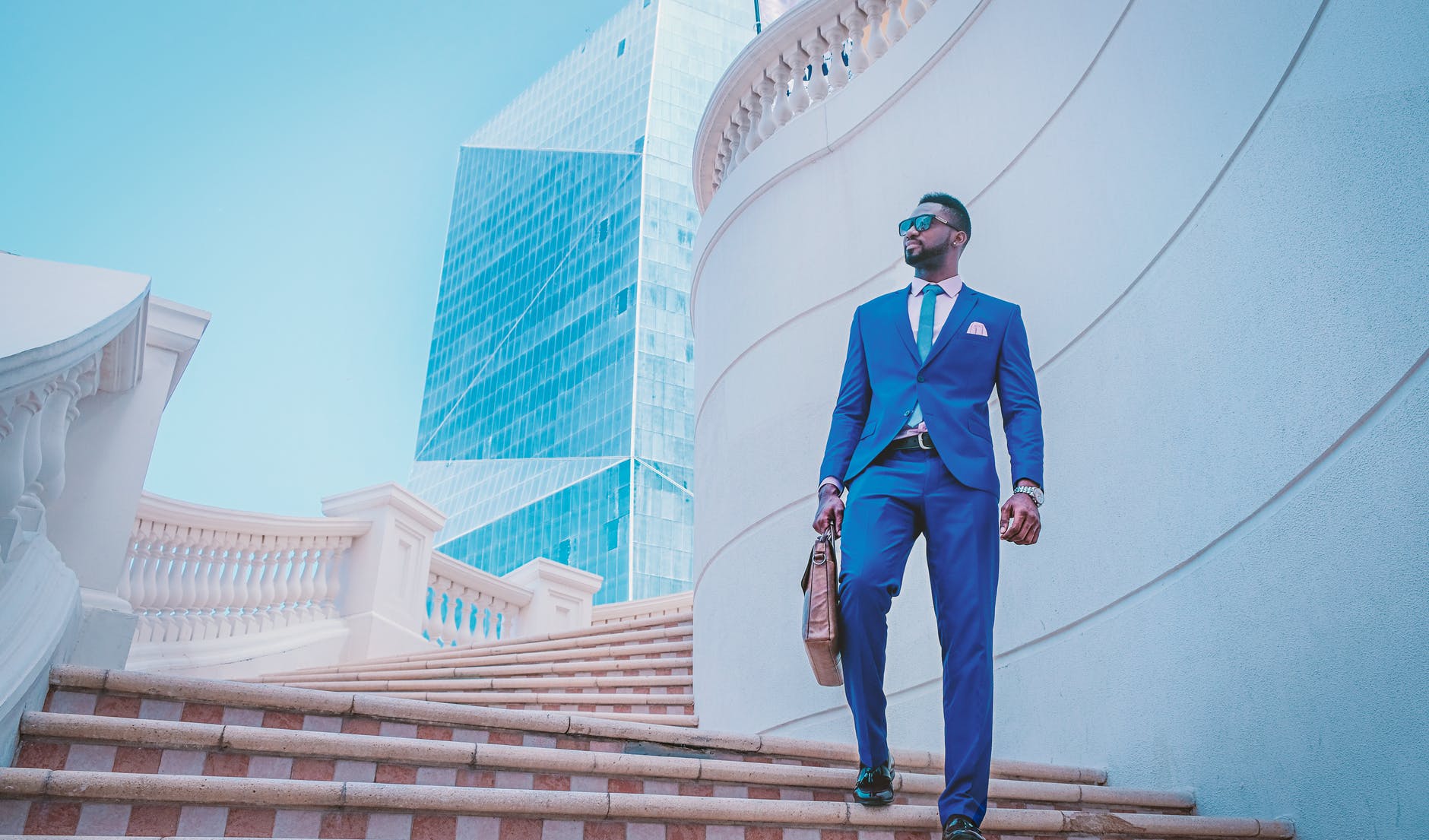 a man in blue suit walking down the stairs