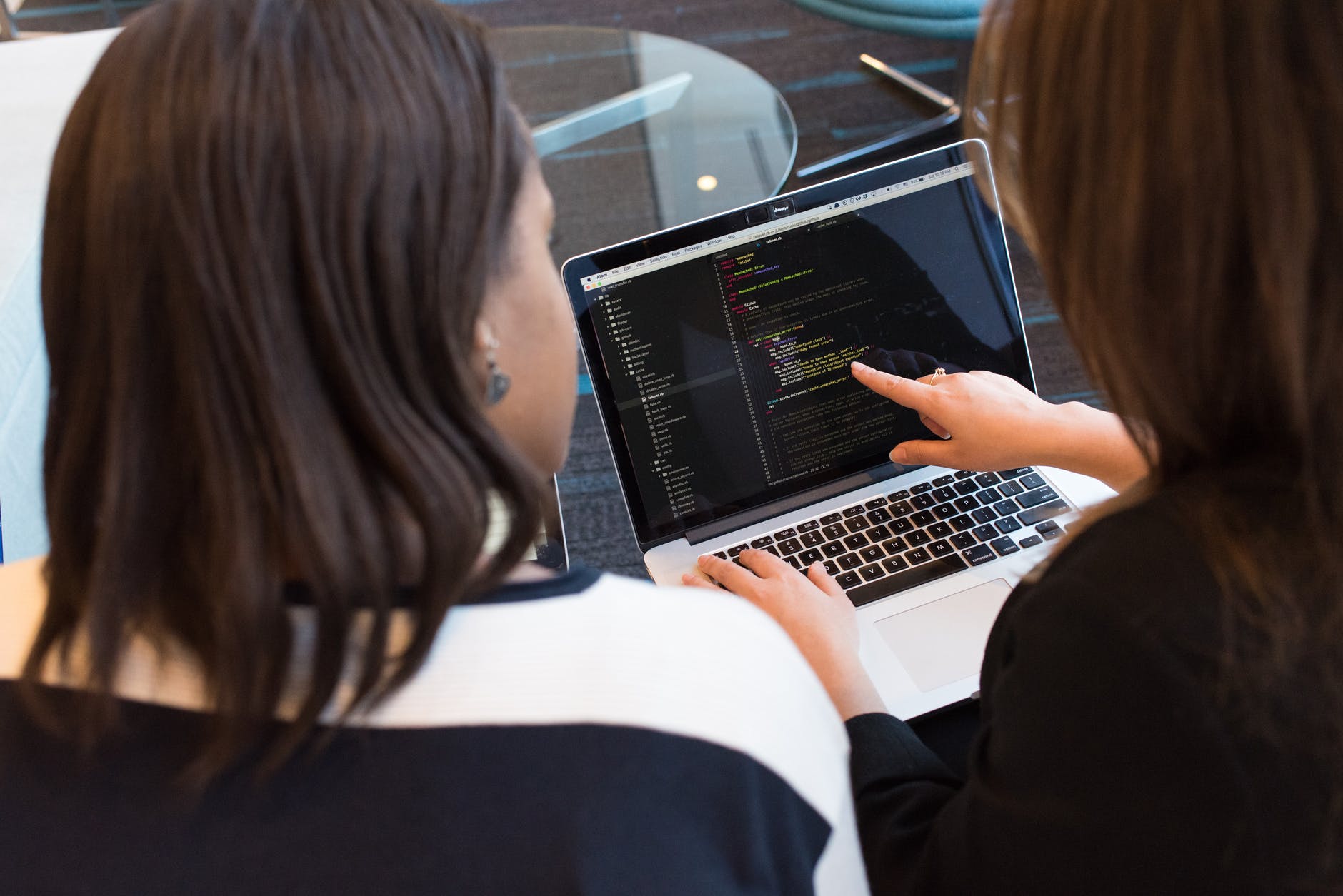 two woman looking at the laptop monitor