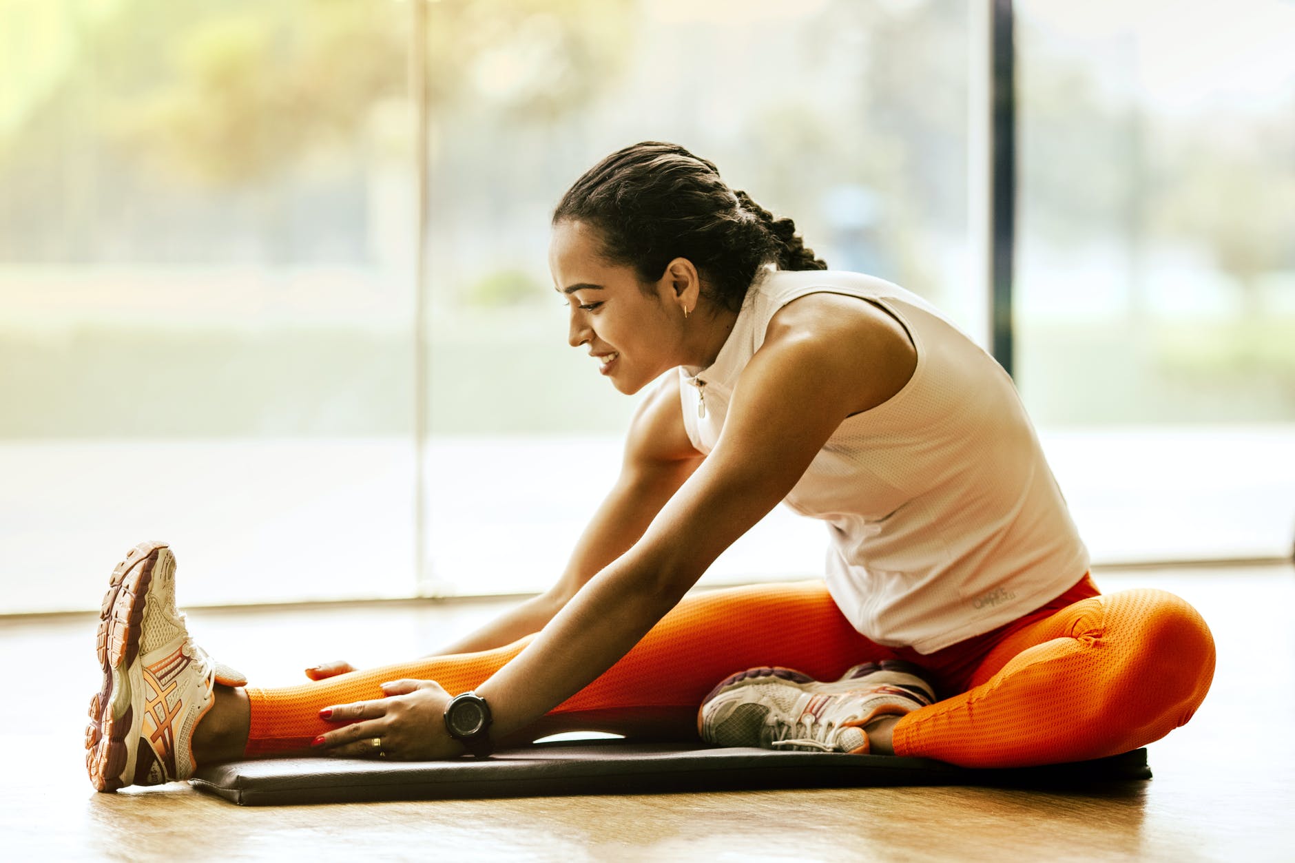 a woman stretching on her orange yoga mat