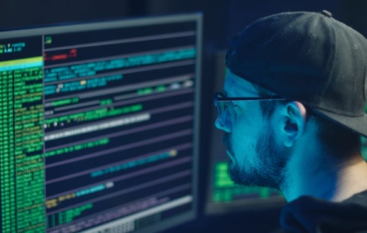 a man looking to his monitor with several codes and text shown