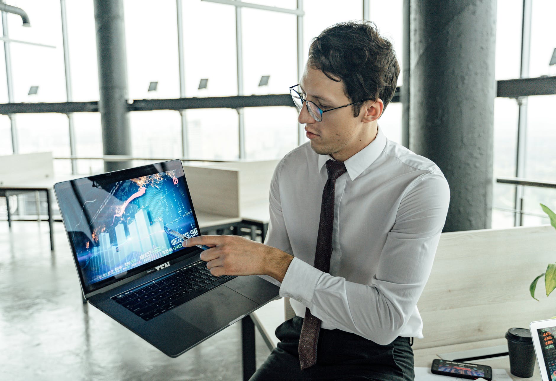 man showing graph in his laptop