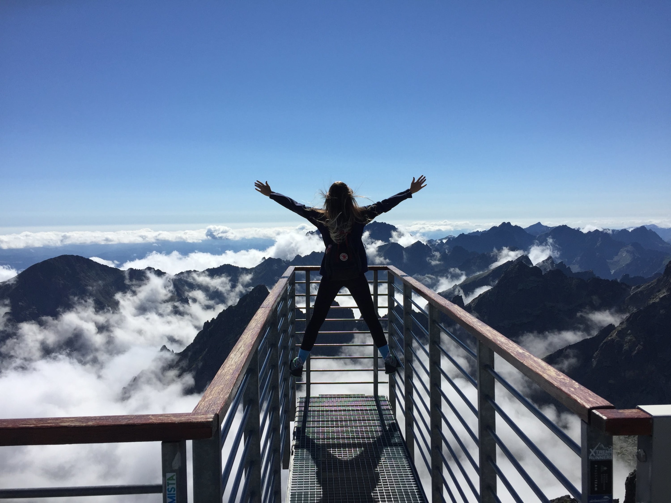a person standing happily with mountain in view