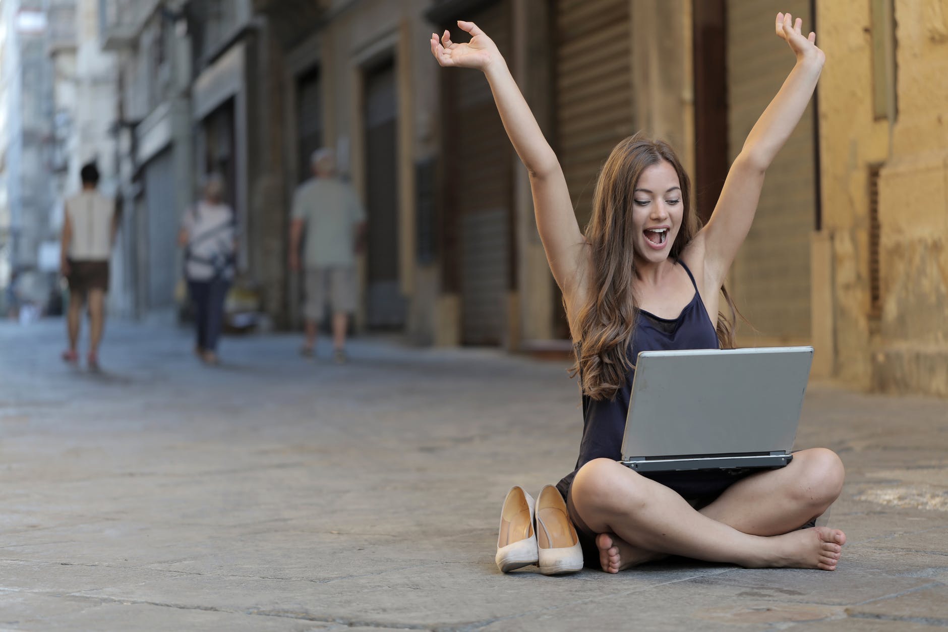 A happy woman raising her hands over her head