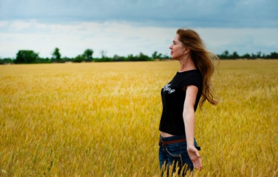 Side view of a woman standing in the middle of a field